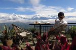 Der perfekte Spot um einen weißen Russen zu genießen. Emanuel Czubatinski above the clouds in Nepal mit Blick auf die schneebedeckten Gipfel des Himalaya.